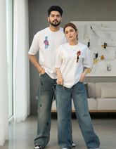 Handsome couple wearing matching white oversized t-shirts in a modern indoor setting