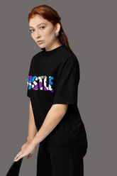 A woman wearing a black crew neck t-shirt with the word 'HUSTLE' printed in multicolored letters on the front Oversized T-Shirt From Kapda Kulture.