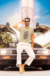 Man sitting on a vintage car with a neon sign in the background Slim Fit T-Shirt From Kapda Kulture.