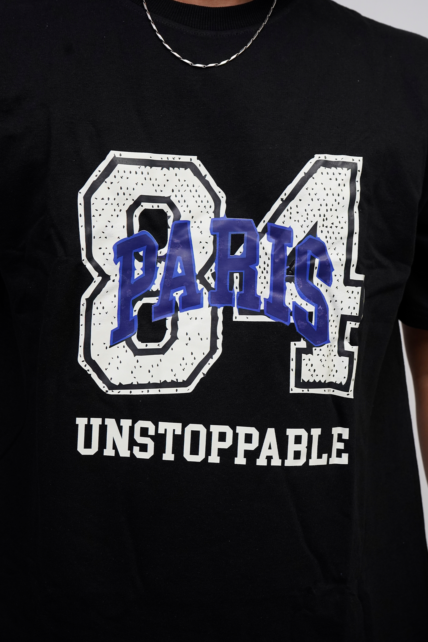 Black t-shirt with '84 Paris Unstoppable' text design on a plain background