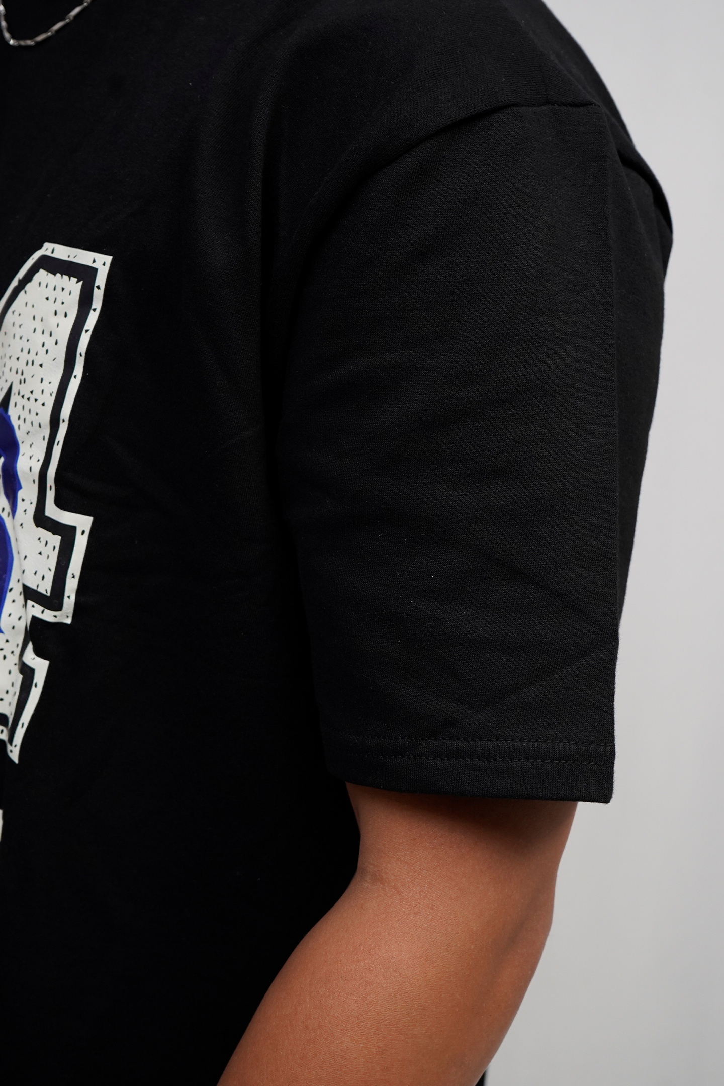 Black t-shirt with a graphic design on a plain background