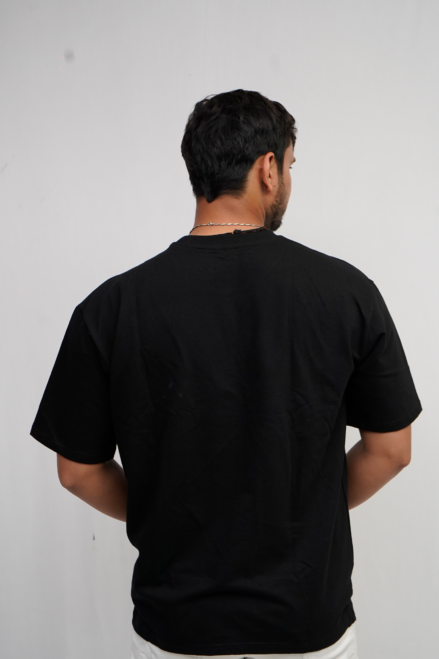 Man wearing a black t-shirt against a plain background