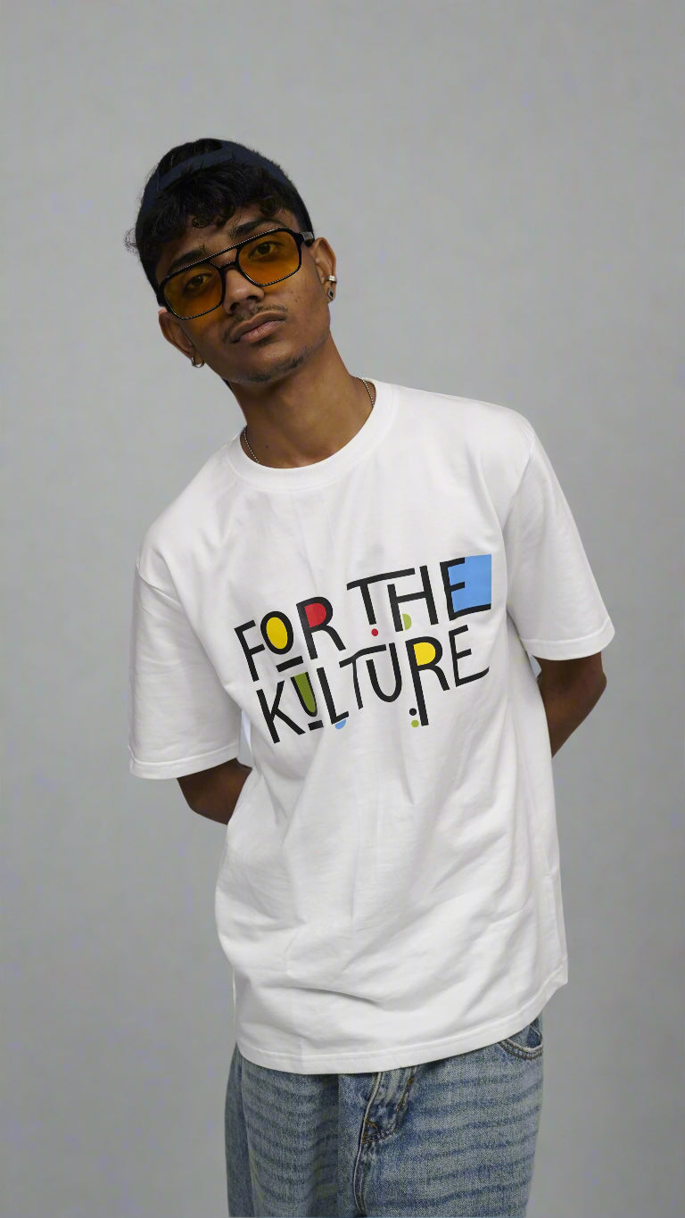 Person wearing a white t-shirt with colorful text on a plain background
