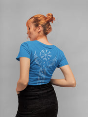 Woman wearing a blue t-shirt with a white design on the back, standing against a gray background
