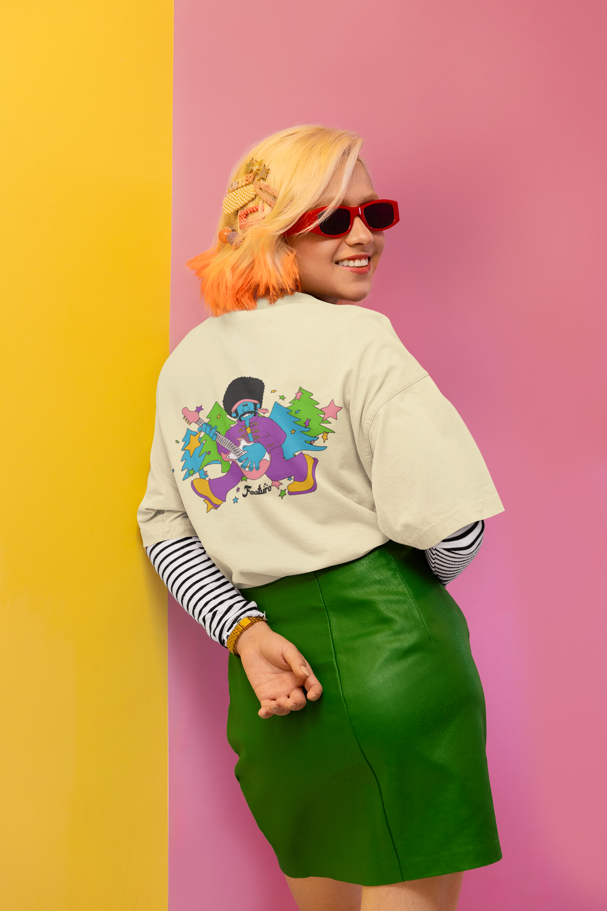 Women wearing a colorful graphic sweatshirt and green skirt against a pink and yellow background Oversized T-Shirt From Kapda Kulture.