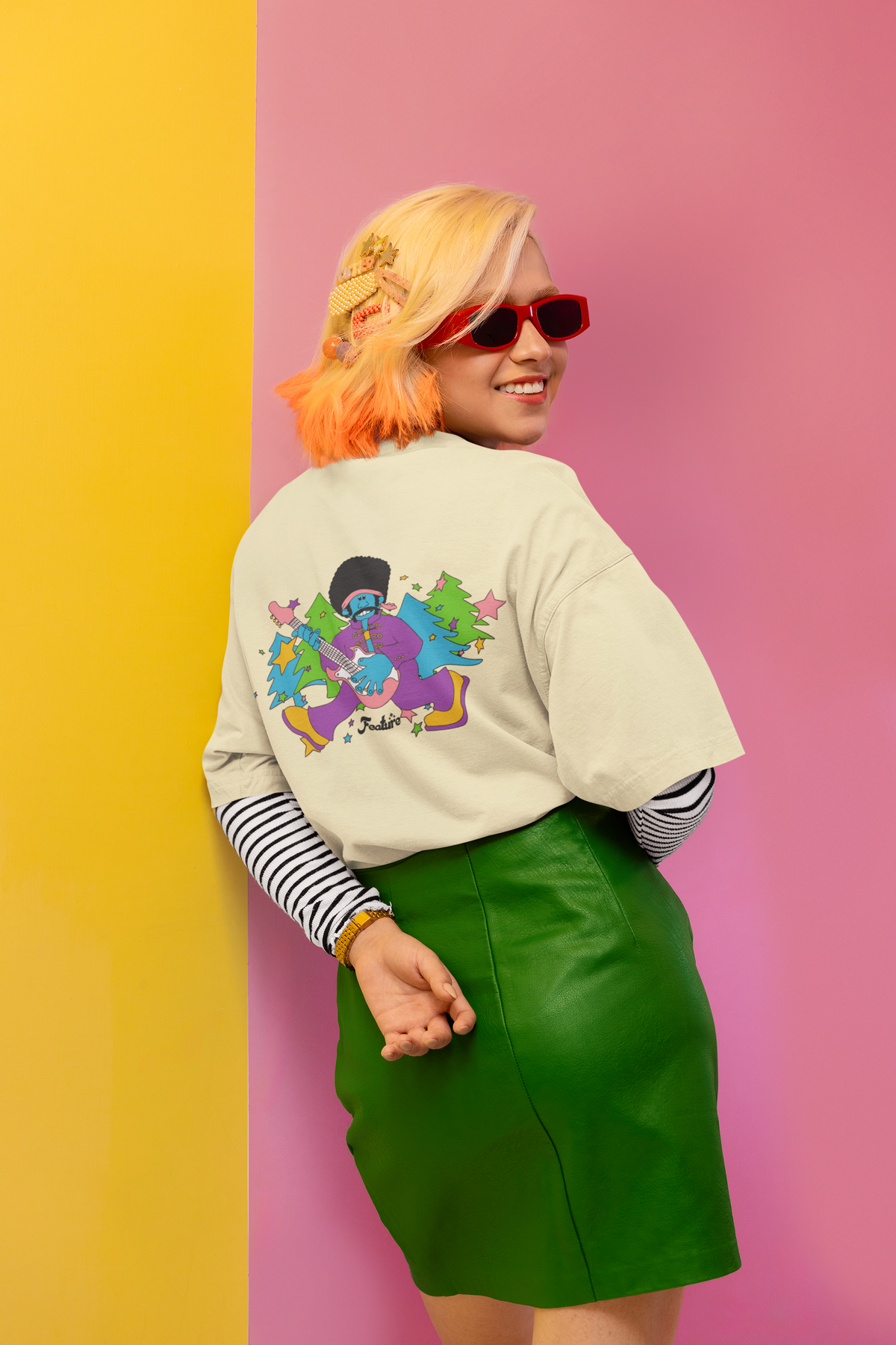 Women wearing a colorful graphic sweatshirt and green skirt against a pink and yellow background Oversized T-Shirt From Kapda Kulture.