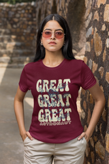 Woman wearing a maroon t-shirt with 'GREAT GREAT GREAT ASTRONAUT' text and sunglasses, standing against a stone wall.