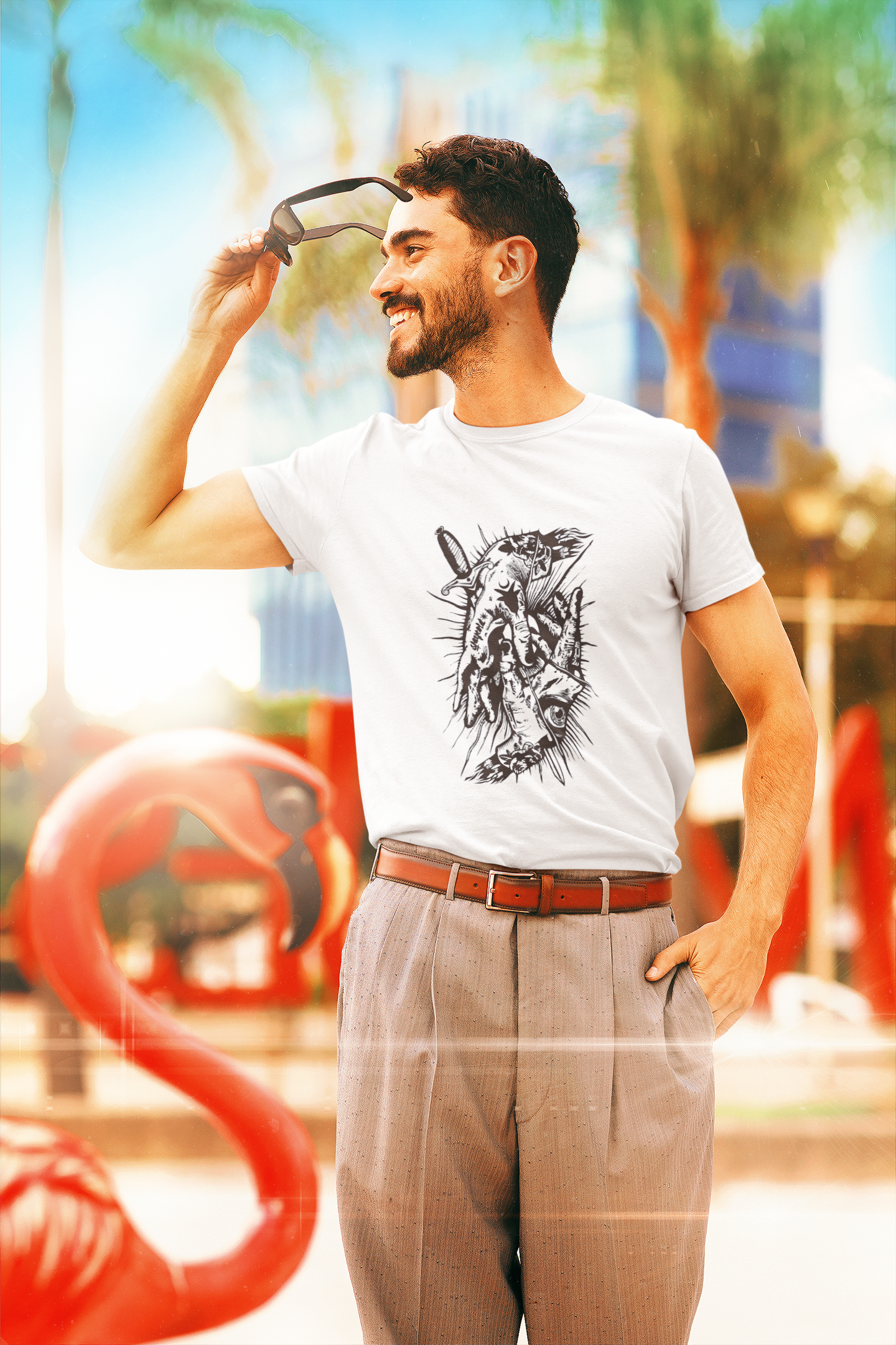 Man wearing a white t-shirt with a graphic design, standing outdoors with colorful background