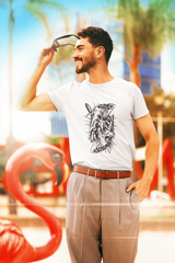 Man wearing a white t-shirt with a graphic design, standing outdoors with colorful background