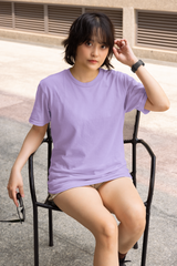 Person wearing a purple t-shirt sitting on a chair outdoors.