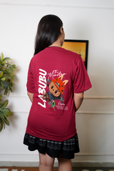 Person wearing a red t-shirt with graphics and text, standing indoors.