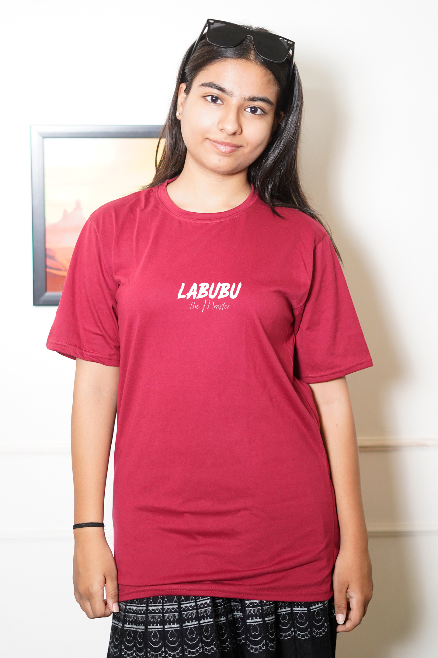 Person wearing a red 'LABIBU' t-shirt indoors with a neutral background