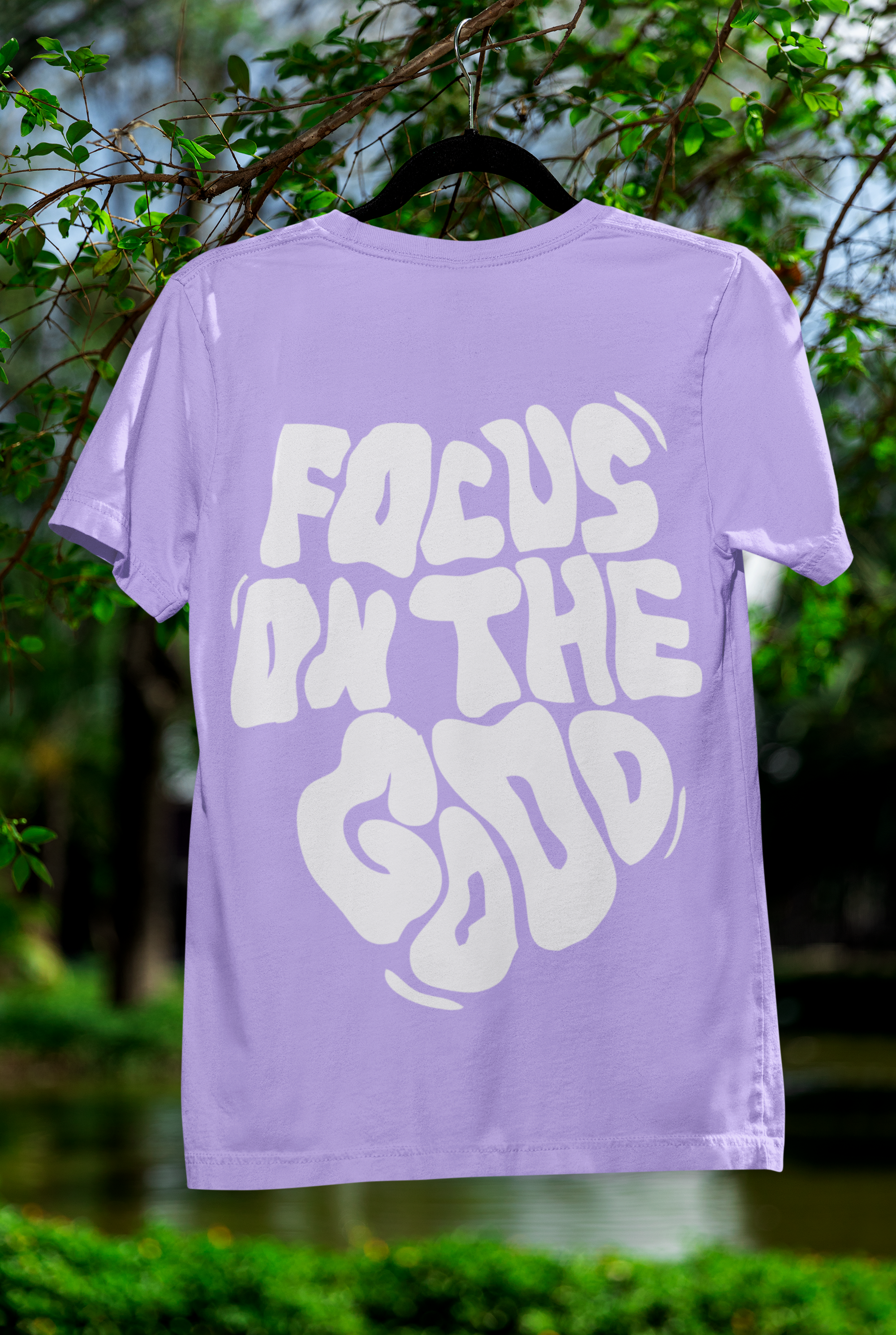 Purple t-shirt with 'Focus on the Good' text on a hanger against a natural background Oversized T-Shirt From Kapda Kulture.