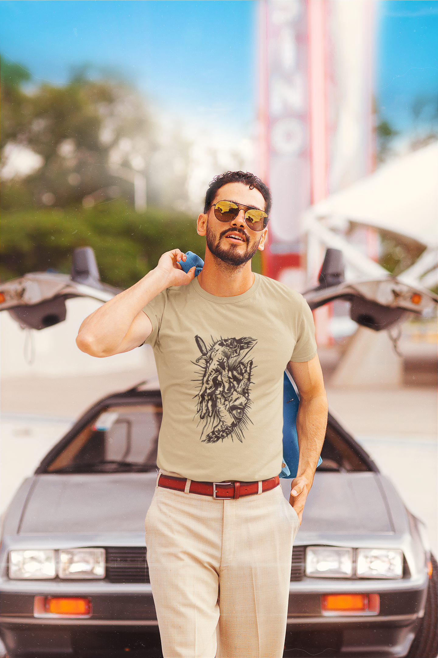 Man wearing a t-shirt with a graphic design in front of a vintage car Slim Fit T-Shirt From Kapda Kulture.