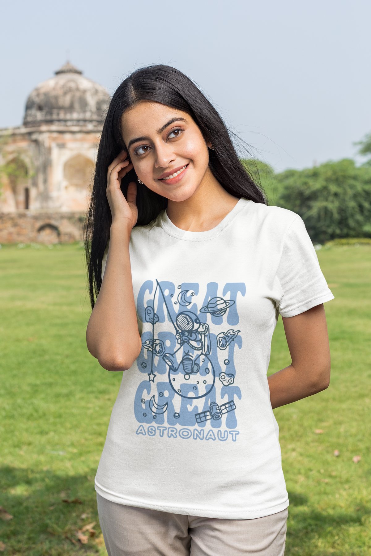 Woman wearing a white t-shirt with a blue graphic design in an outdoor setting