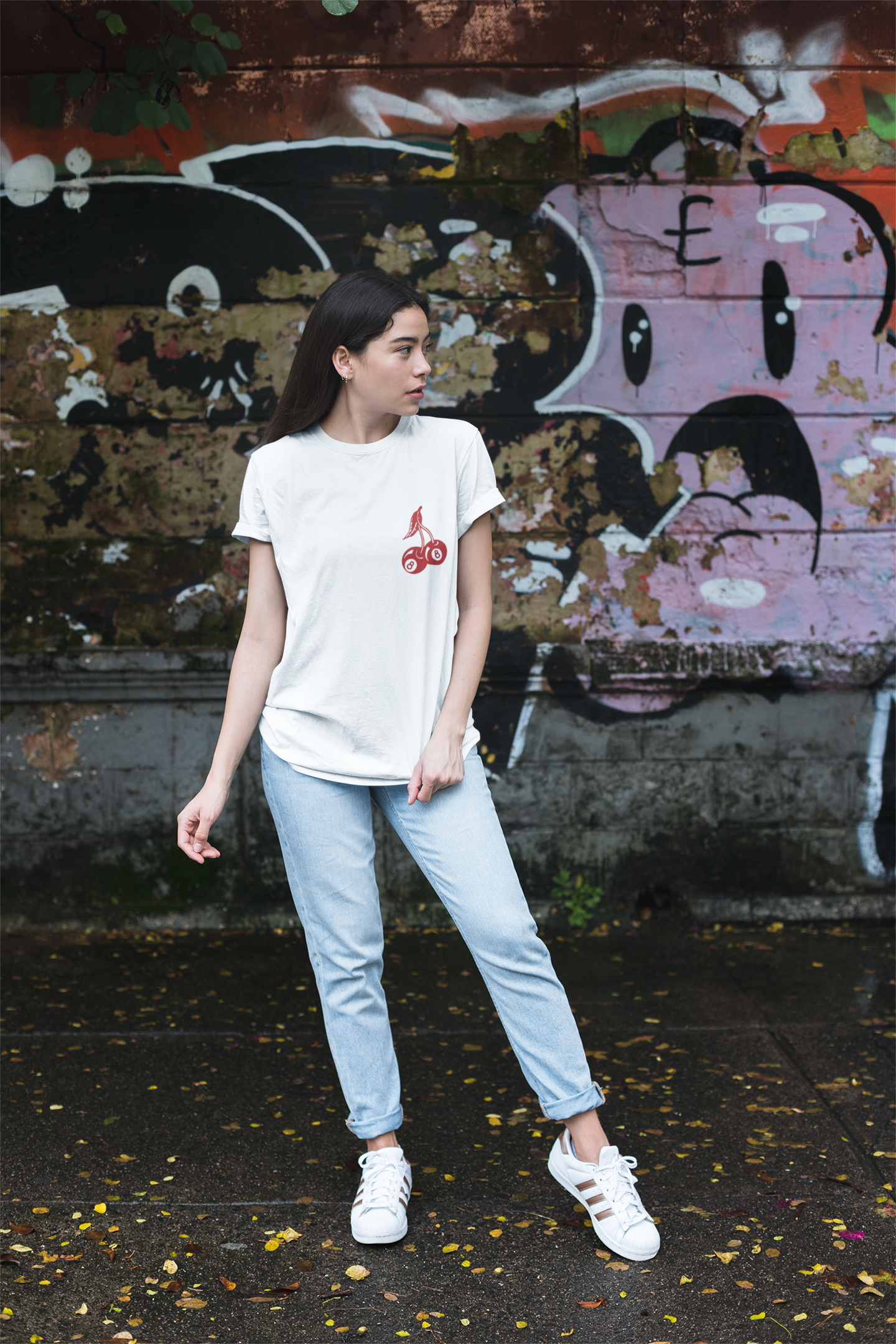 A woman wearing a white t-shirt with a graphic on the front, light blue jeans.