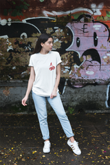 A woman wearing a white t-shirt with a graphic on the front, light blue jeans.